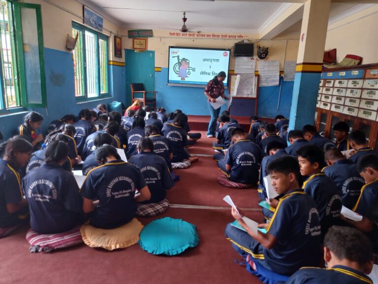 The students are facing towards the screen that reads "लैङ्गिक हिंसा र अपाङ्गता". Everyone is filling pre-questionnaire.